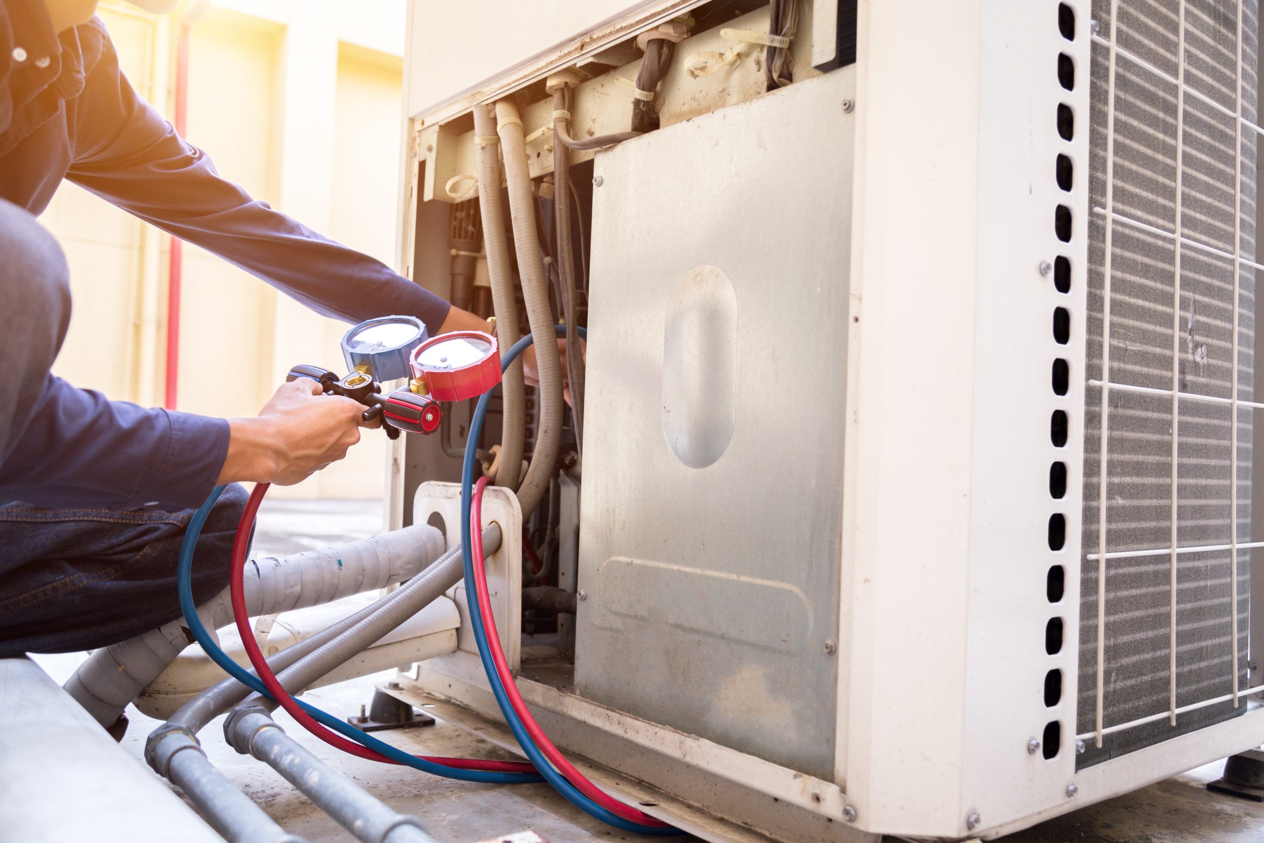 man fixing air conditioning unit.